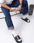 Stylish eco-friendly navy blue sliders paired with white socks and cargo denim