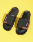 Solid Hues black tan sliders top view showing tan upper and black sole on a yellow background.