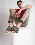 A young man pairs white and olive men’s sliders with cargo pants and a solid red T-shirt, creating a bold yet relaxed casual look.