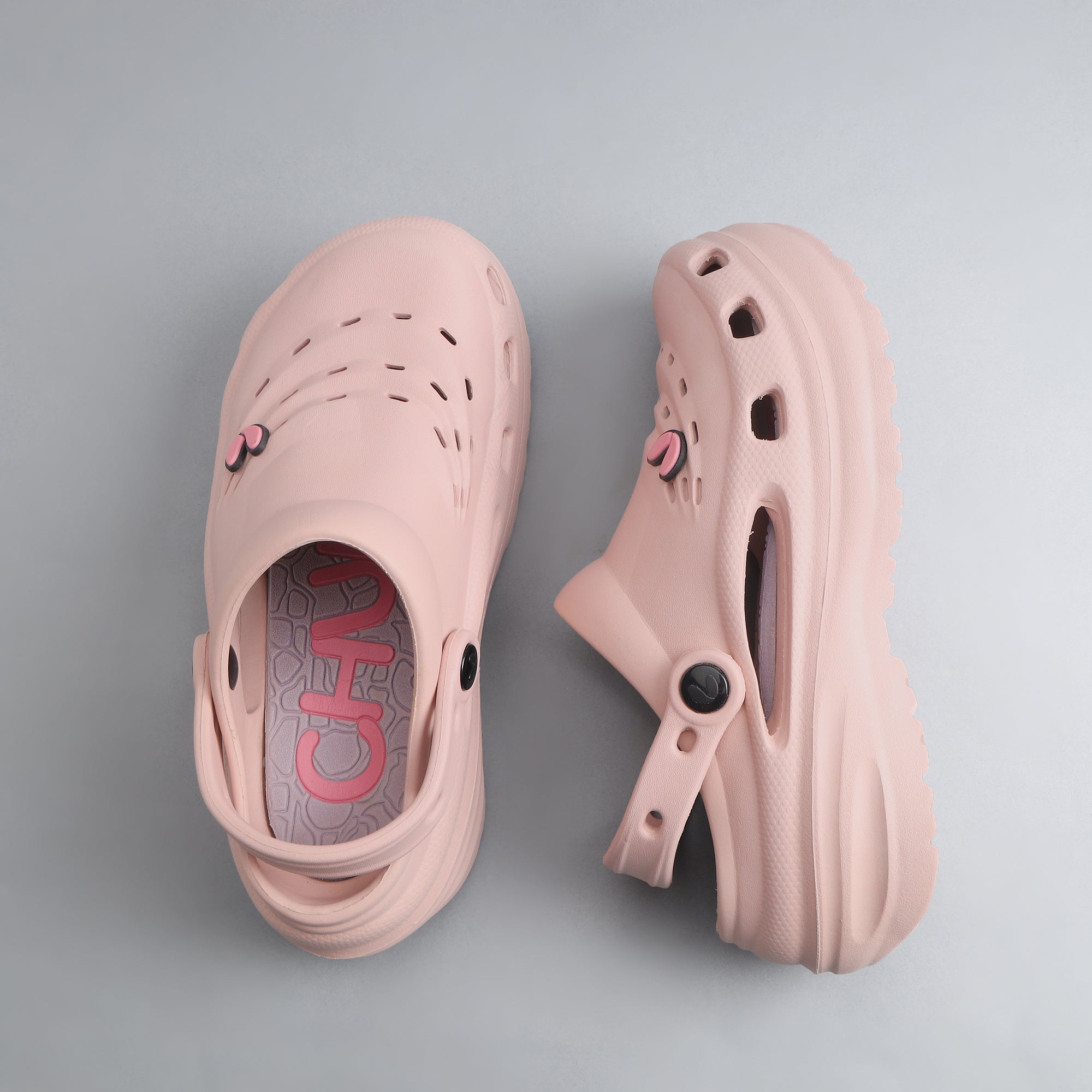 Pair of pink clogs on a gray background which is Water-resistant and quick-dry