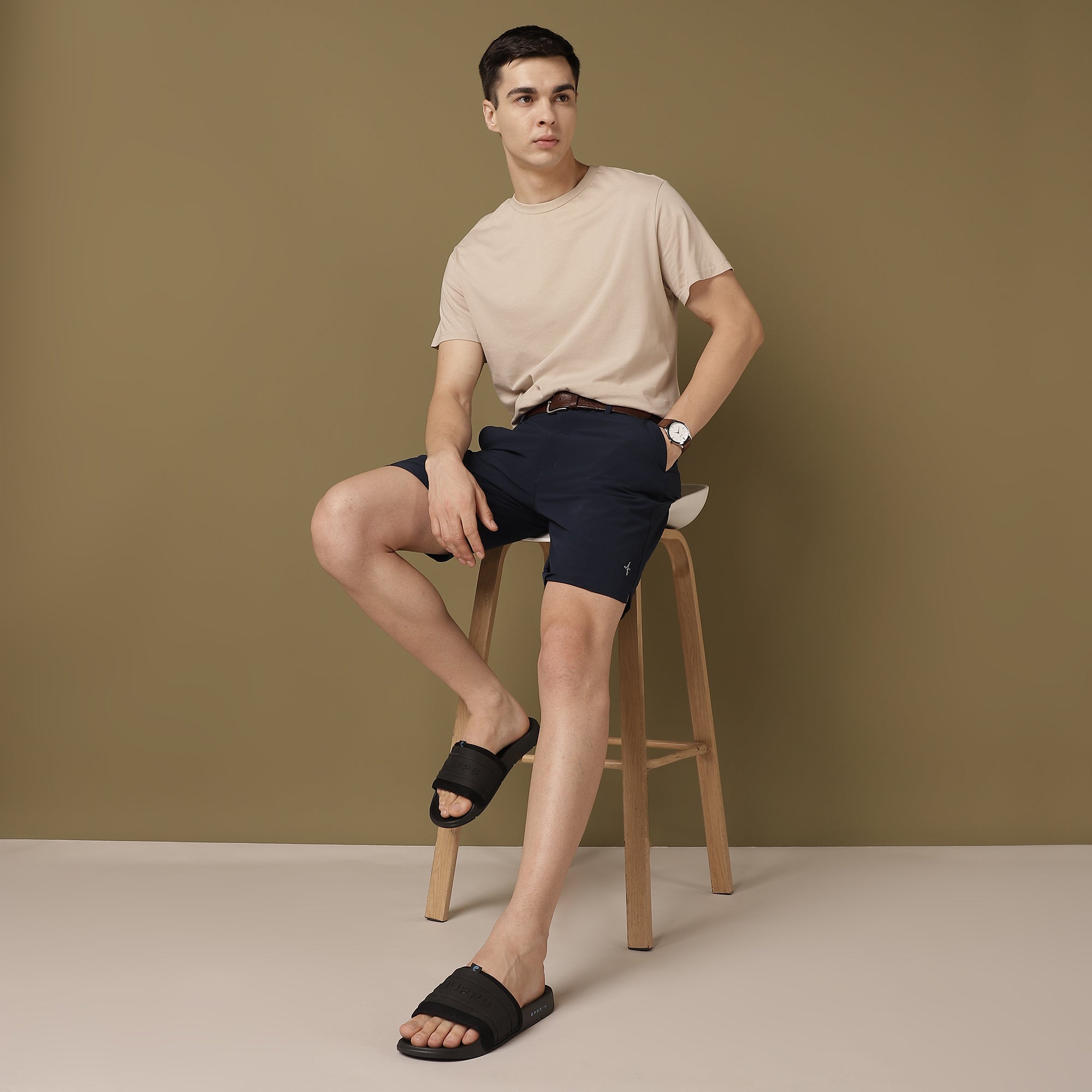 model picture of rover wearing beige T-shirt and blue shorts with black flip-flops