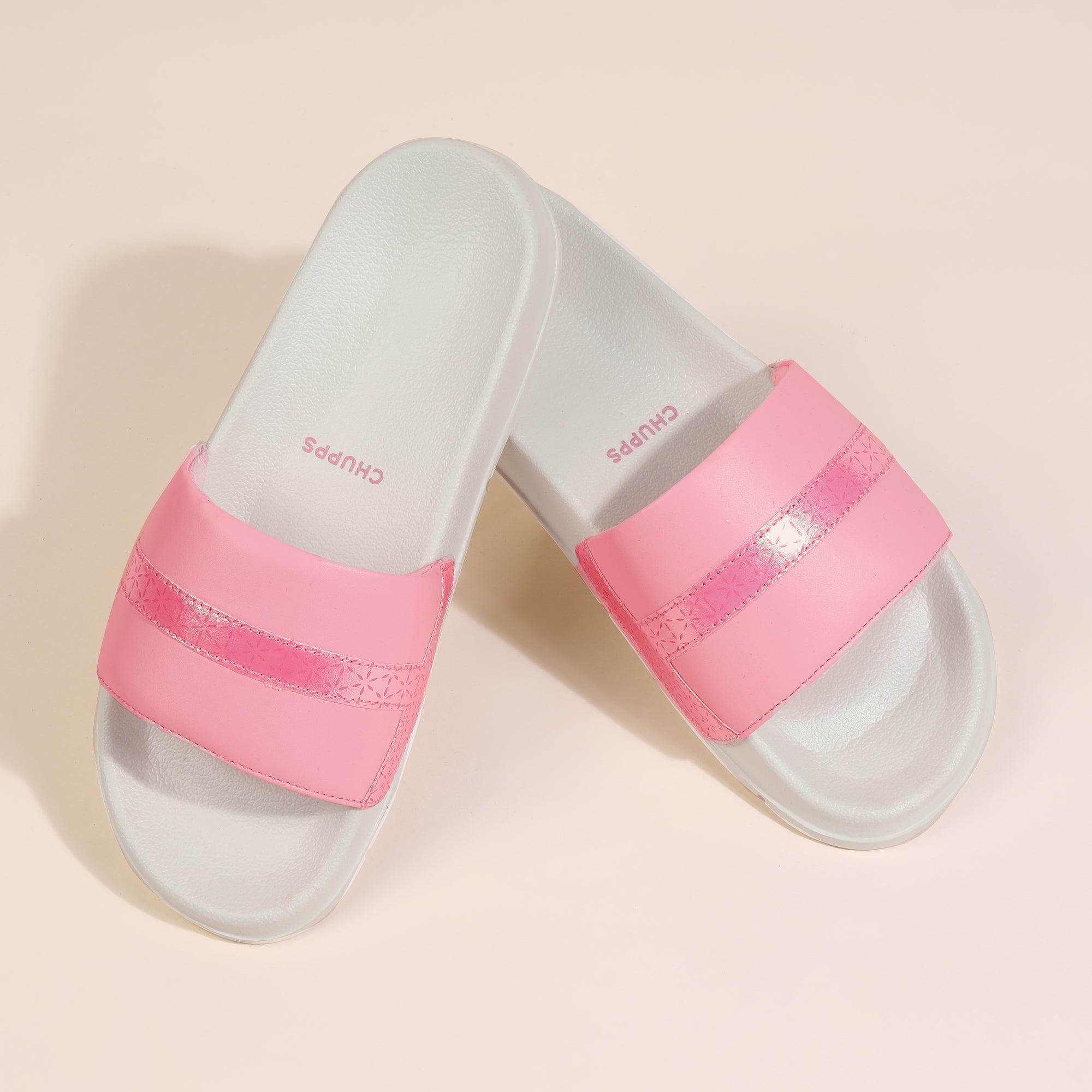 Pink and clear slide sandals on a beige background