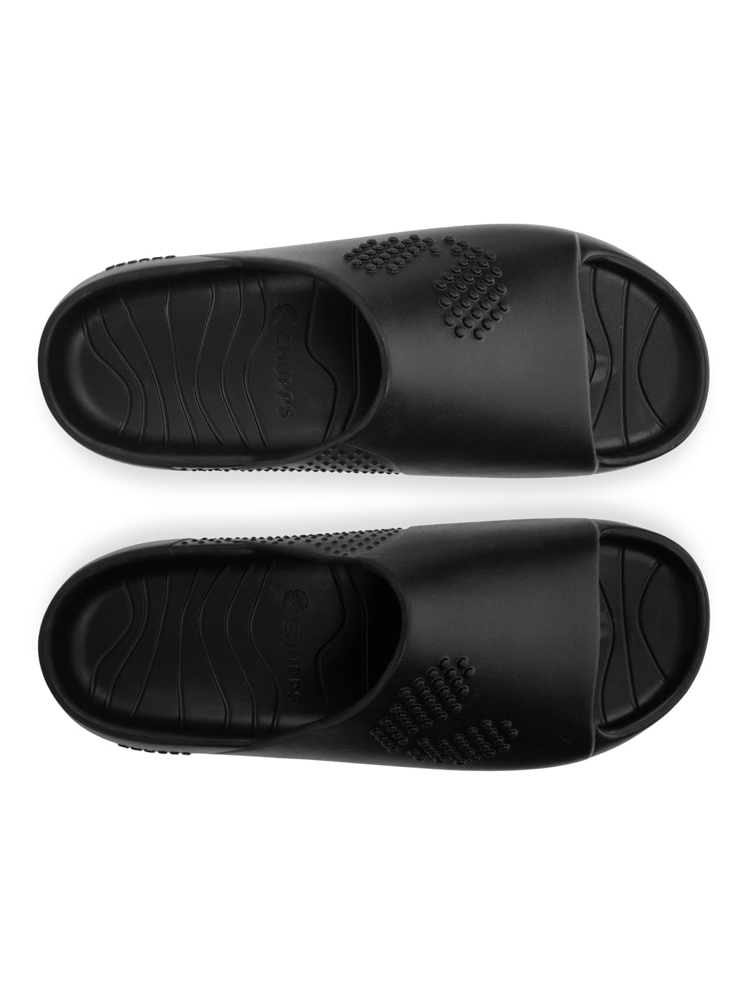 Pair of black slides on a white background with Close-up of men’s foot resting in the deep footbed for everyday comfort .